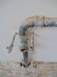 Home 6 Plumber inspecting a pipe for a sewage backup insurance California claim