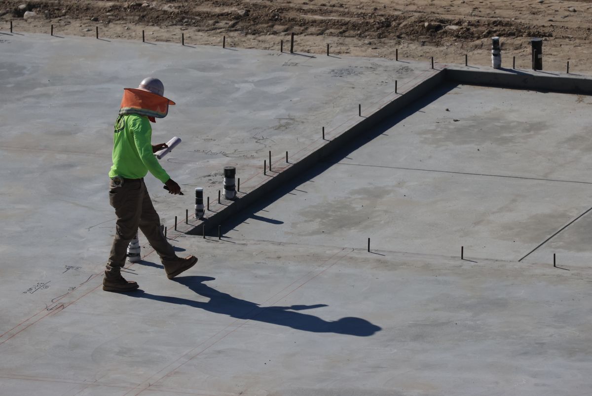 Technician checking a concrete slab for remaining moisture before slab leak drying is complete